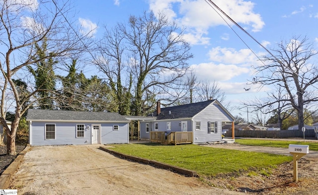 ranch-style home featuring an outbuilding, driveway, a front yard, and fence