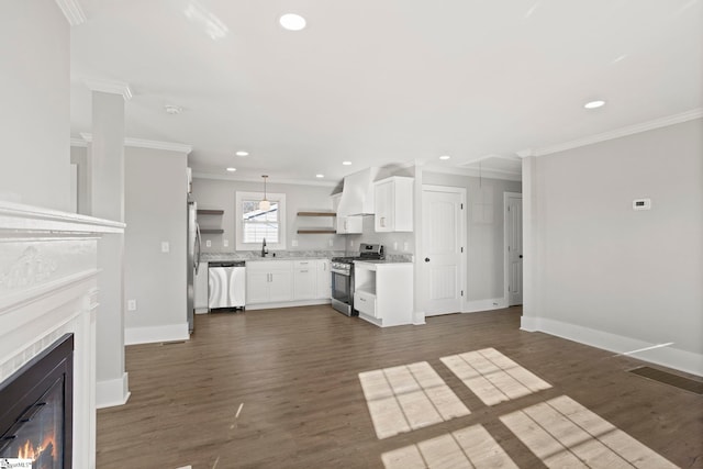 unfurnished living room featuring dark wood finished floors, a glass covered fireplace, crown molding, and baseboards