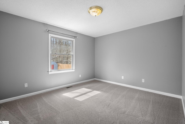 unfurnished room featuring visible vents, a textured ceiling, baseboards, and carpet floors