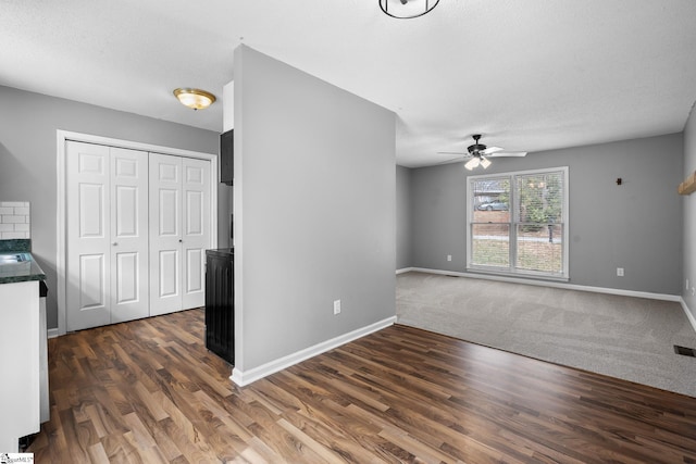 interior space featuring visible vents, baseboards, dark wood-type flooring, and ceiling fan