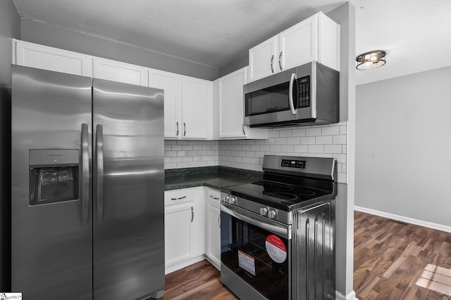 kitchen featuring backsplash, stainless steel appliances, a textured ceiling, white cabinetry, and dark wood-style flooring