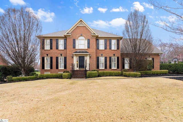 view of front of house featuring a front yard and brick siding