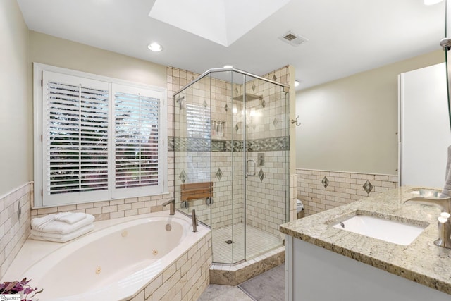 bathroom with visible vents, a shower stall, tile walls, a whirlpool tub, and vanity