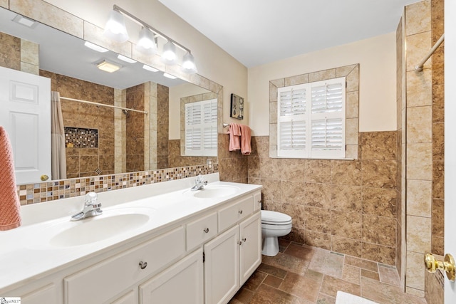 full bath featuring tile walls, toilet, tiled shower, and a sink