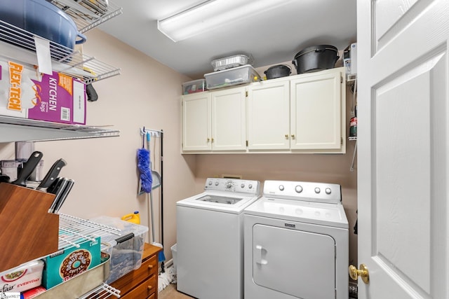 clothes washing area with cabinet space and separate washer and dryer