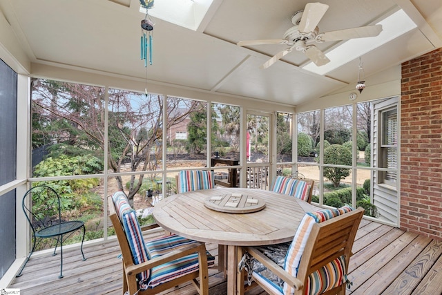 sunroom / solarium with lofted ceiling with skylight and a ceiling fan