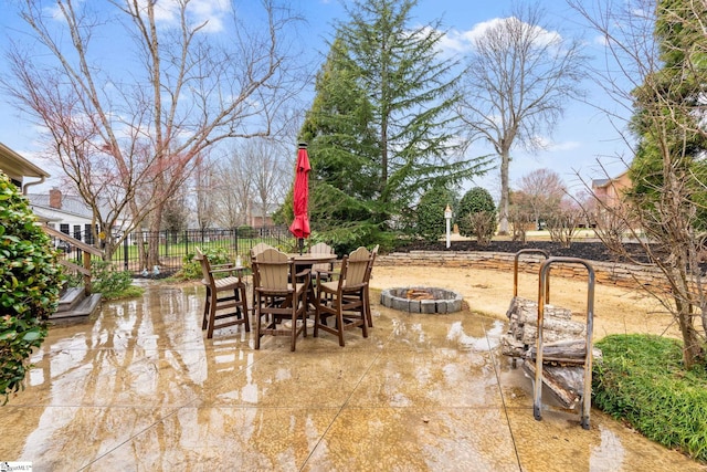 view of patio / terrace with outdoor dining area, fence, and an outdoor fire pit