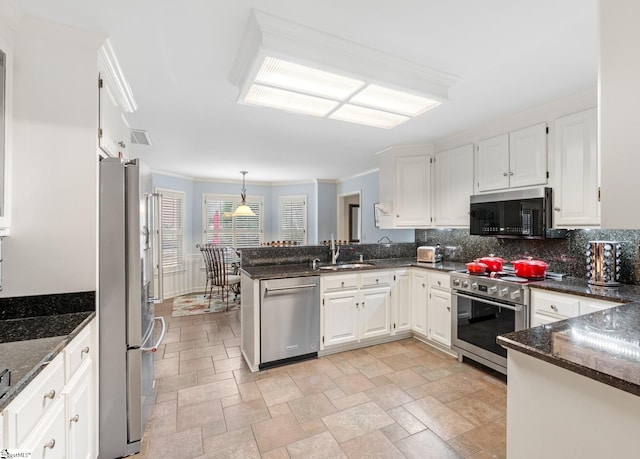 kitchen featuring a sink, stainless steel appliances, a peninsula, and white cabinets