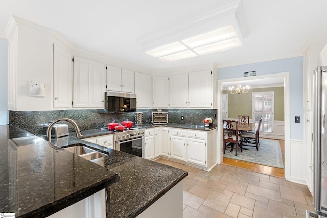 kitchen with tasteful backsplash, crown molding, white cabinets, stainless steel appliances, and a sink