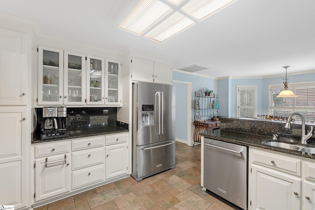 kitchen with visible vents, stone finish floor, a sink, white cabinetry, and appliances with stainless steel finishes