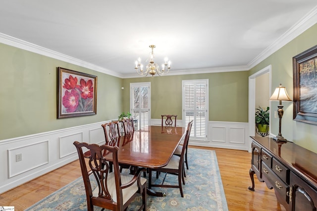 dining space featuring a chandelier, crown molding, and light wood-style floors