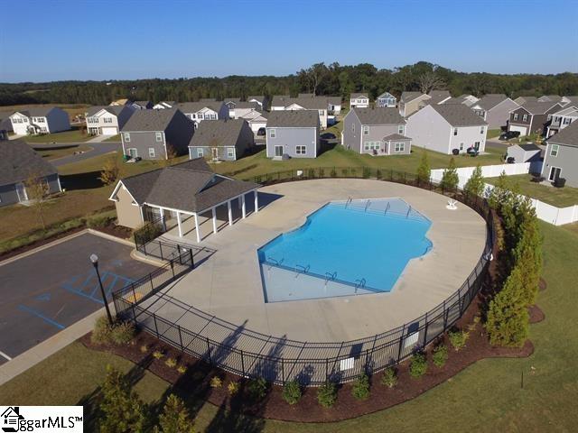 community pool with a patio, fence, and a residential view