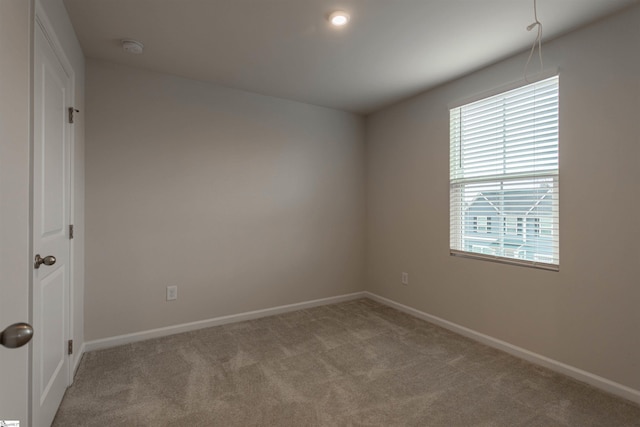 unfurnished room with carpet flooring and baseboards