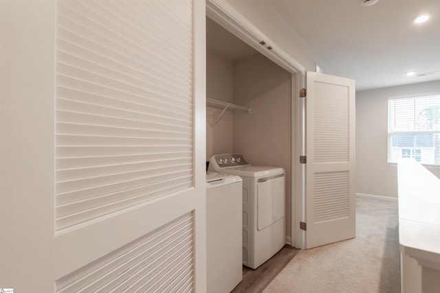 washroom with baseboards, washer and clothes dryer, light colored carpet, laundry area, and recessed lighting