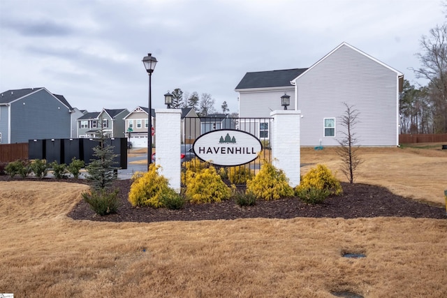 community sign with a residential view, a lawn, and fence