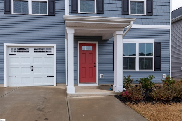 property entrance with an attached garage and driveway