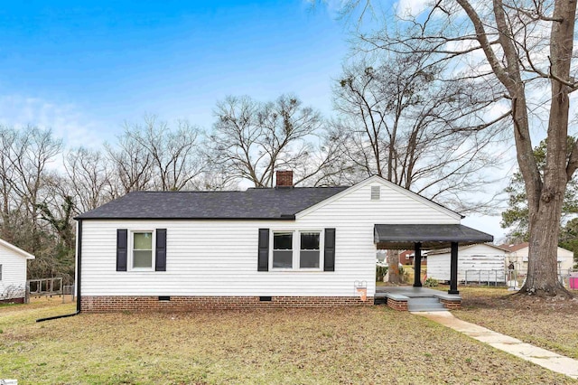 view of front of property with crawl space, roof with shingles, a chimney, and a front yard