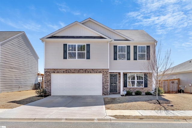 view of front of home featuring concrete driveway, a garage, fence, and brick siding