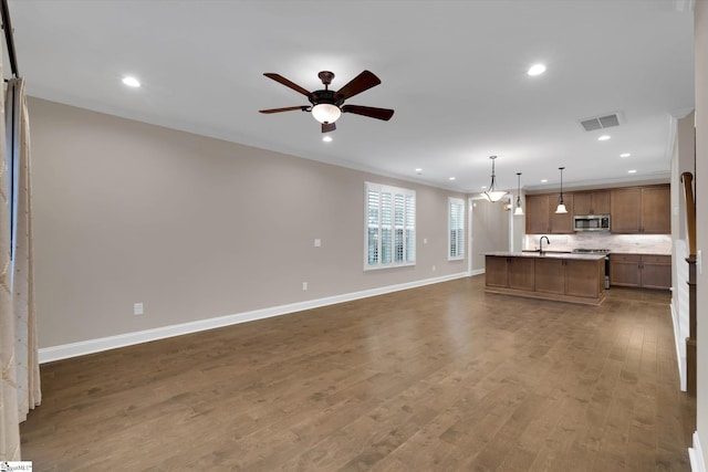 kitchen with visible vents, an island with sink, open floor plan, appliances with stainless steel finishes, and dark wood-style flooring