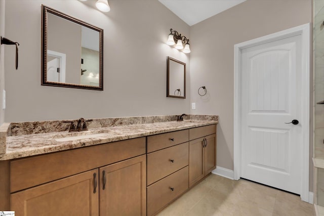 full bath with a sink, baseboards, double vanity, and tile patterned flooring