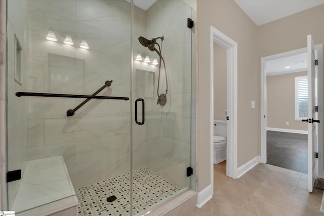 full bath featuring tile patterned flooring, a shower stall, toilet, and baseboards