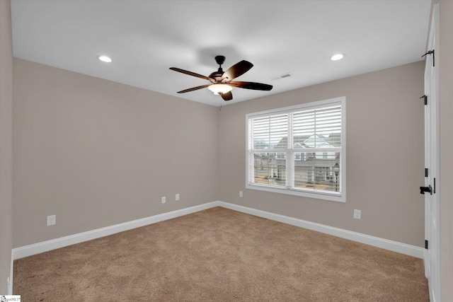 empty room featuring a ceiling fan, baseboards, visible vents, recessed lighting, and light carpet