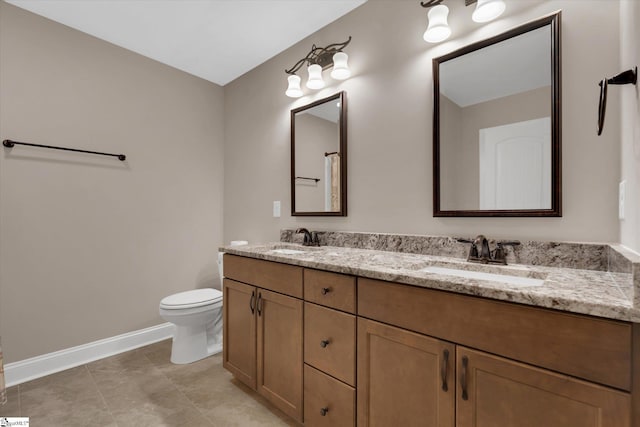 bathroom with double vanity, toilet, baseboards, and a sink