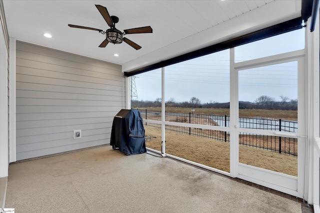 sunroom / solarium featuring a ceiling fan