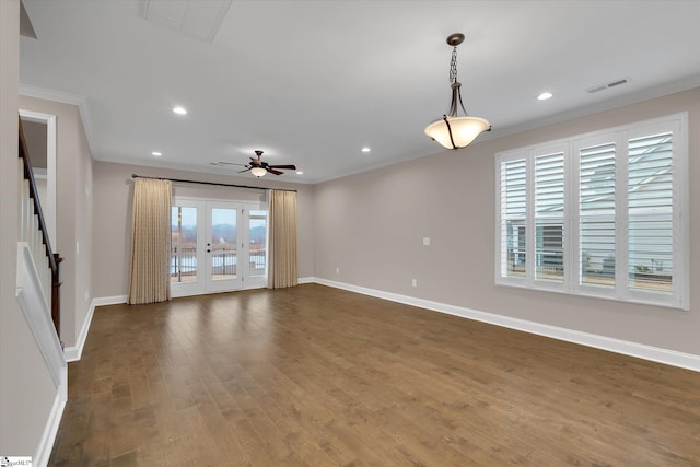 empty room with dark wood-style flooring, stairway, baseboards, and ornamental molding