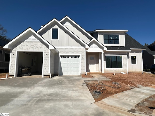 view of front of property with a garage, board and batten siding, driveway, and a shingled roof