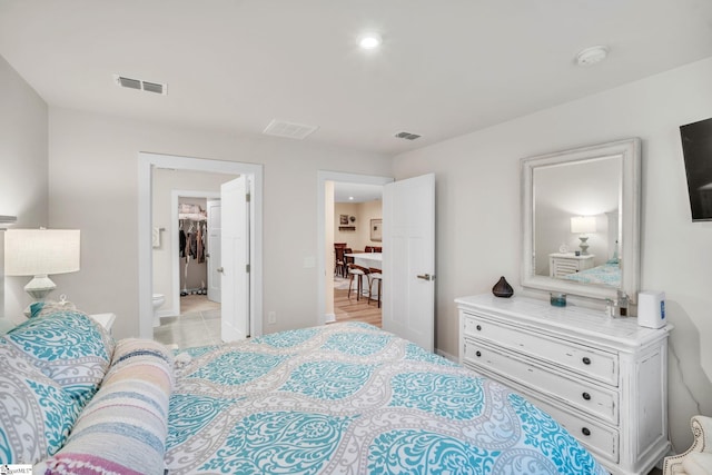 bedroom with a spacious closet and visible vents