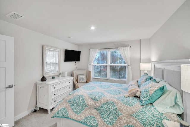 bedroom featuring visible vents, multiple windows, light colored carpet, and baseboards