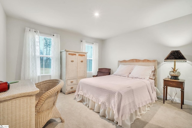 bedroom featuring baseboards and light carpet