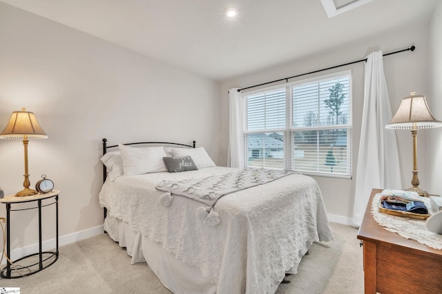 bedroom featuring baseboards and light carpet