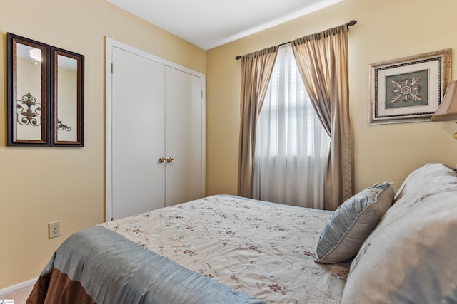 bedroom featuring a closet, baseboards, and carpet flooring