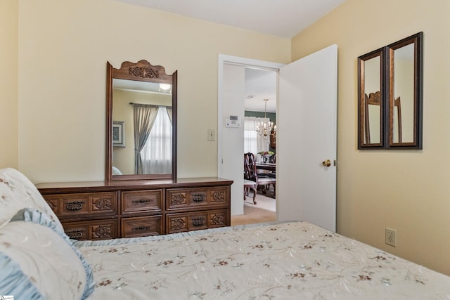 bedroom with light carpet and a chandelier