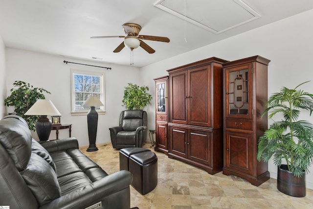 interior space with visible vents, attic access, ceiling fan, and stone finish flooring