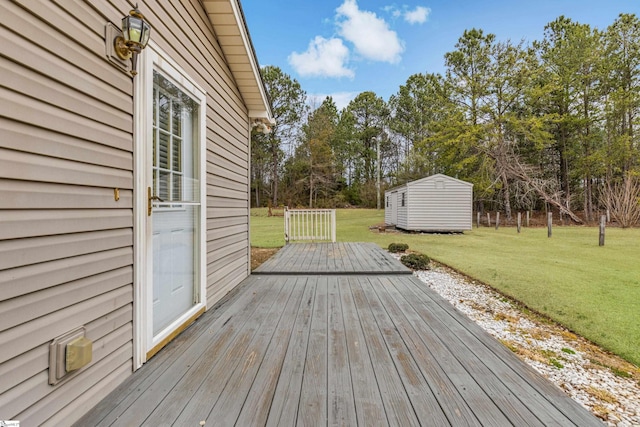 wooden terrace featuring a lawn, a storage unit, and an outdoor structure