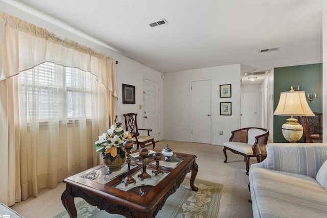 living area featuring visible vents and light carpet