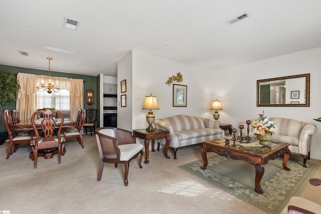 living room with light carpet, visible vents, and a chandelier