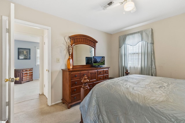 bedroom with a ceiling fan, light colored carpet, visible vents, and baseboards