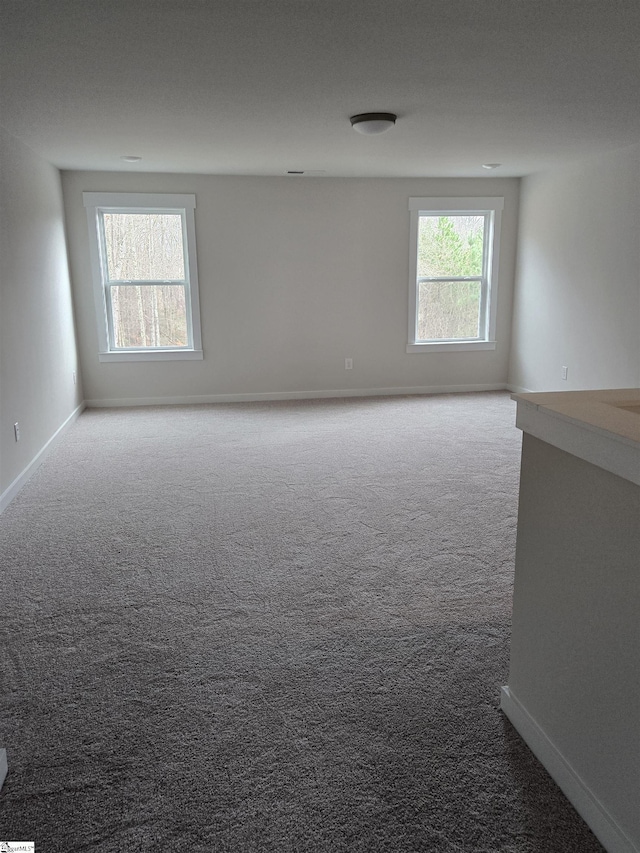 carpeted spare room with baseboards