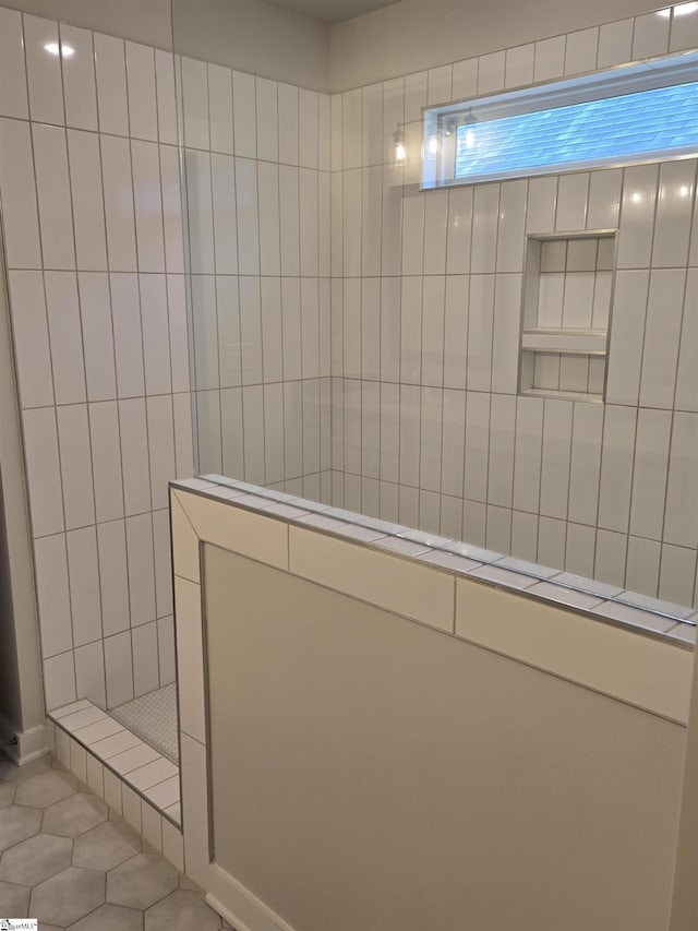 bathroom with walk in shower and tile patterned flooring