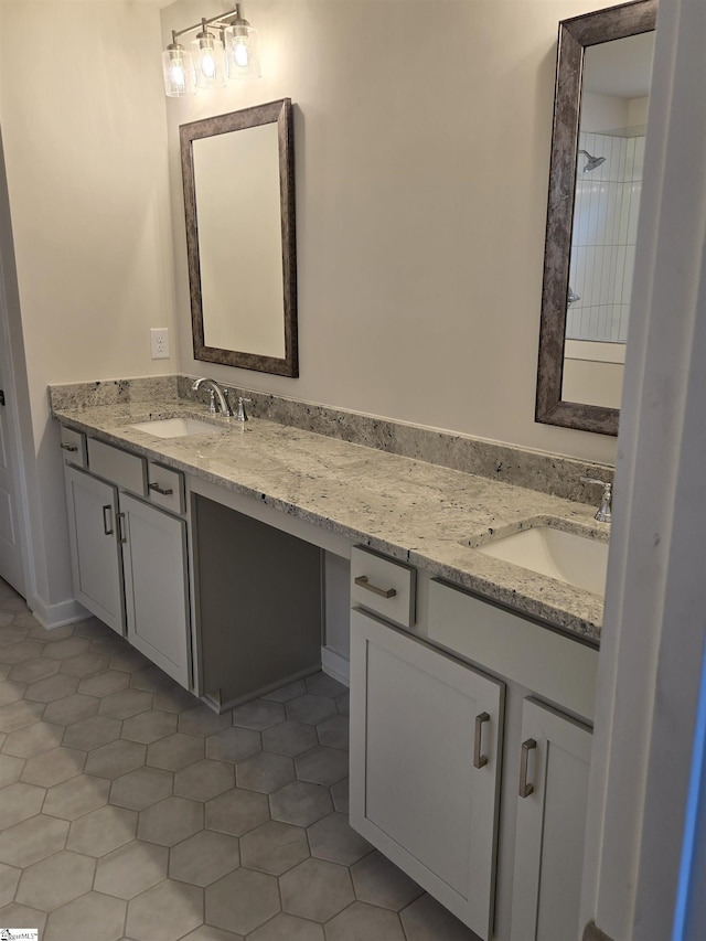 bathroom with double vanity, tile patterned floors, a shower, and a sink