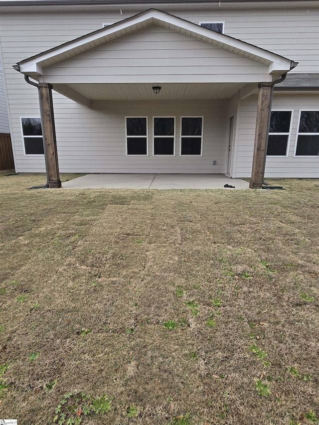 rear view of house featuring a patio area and a lawn