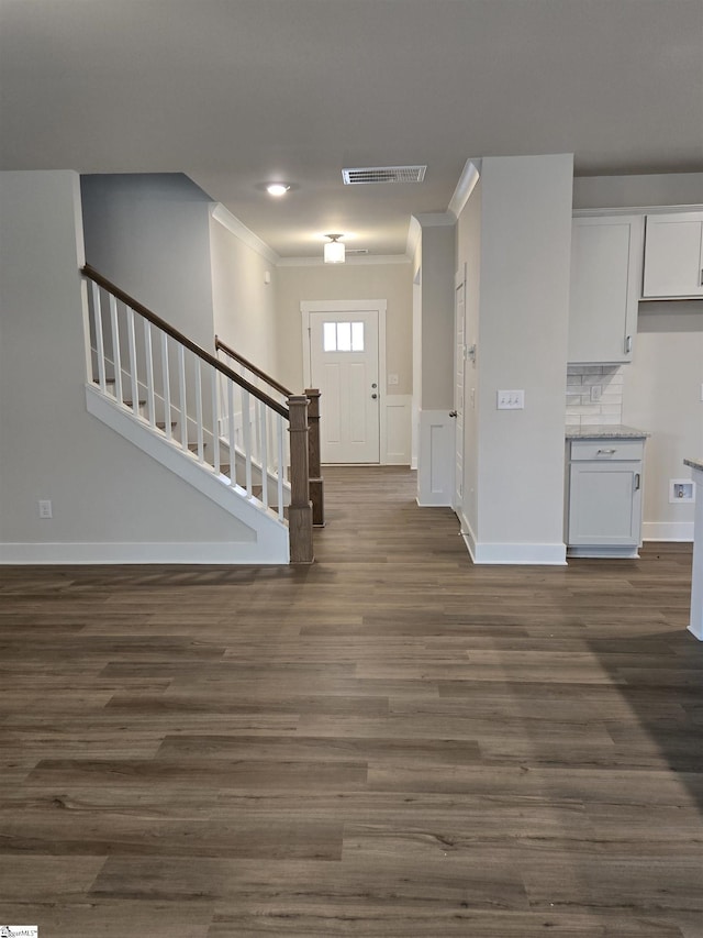 entrance foyer featuring stairway, visible vents, dark wood-style flooring, and crown molding