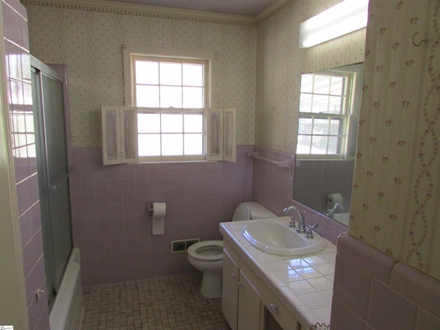 full bath with wallpapered walls, toilet, vanity, and a wainscoted wall