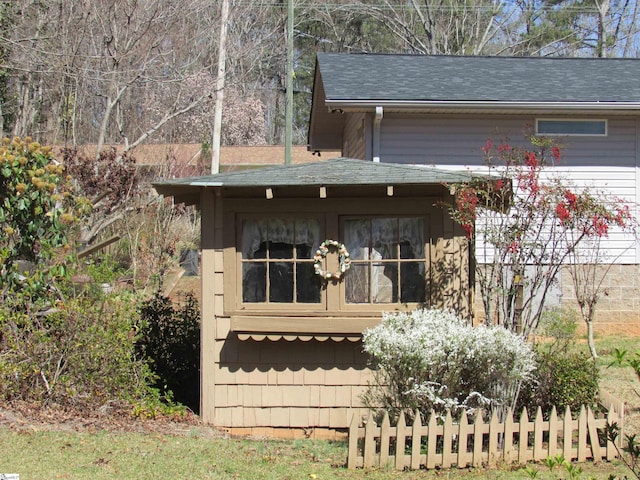 exterior space featuring roof with shingles