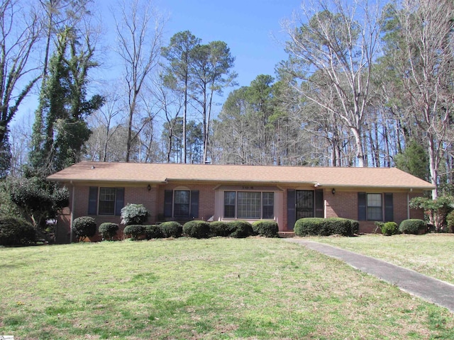 ranch-style house featuring brick siding and a front yard