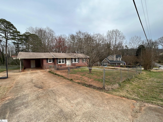 single story home featuring a front yard, a carport, concrete driveway, a fenced front yard, and brick siding